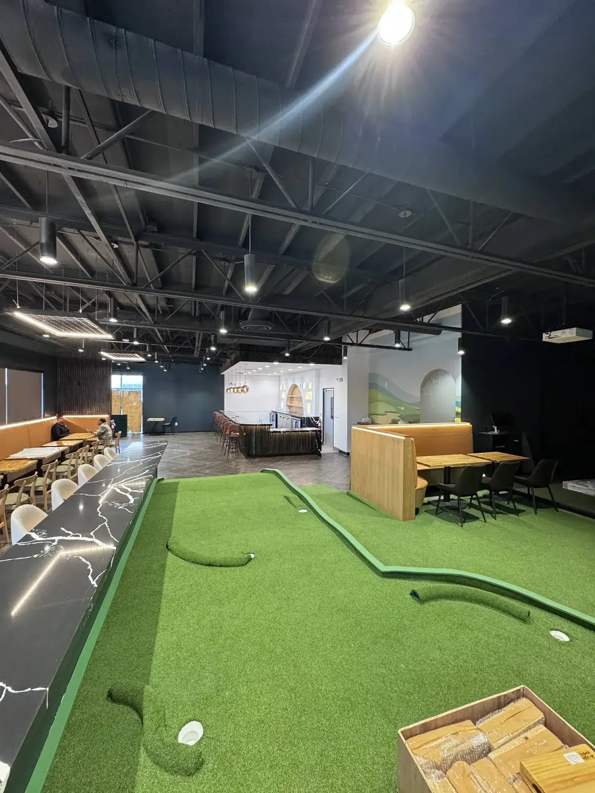 The indoor putt-putt course running past the bar