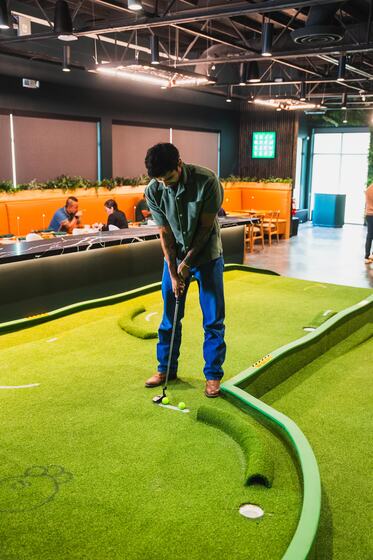 Putting on the indoor course with the bar behind